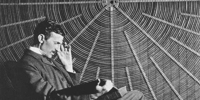Nikola Tesla  leyendo frente a la espiral de la bobina de su transformador de alta tensión en East Houston Street, Nueva York