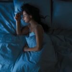 top-view-of-beautiful-young-woman-sleeping-cozily-on-a-bed-in-his-at-picture-id1156679499