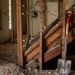 redhandled-shovel-leans-against-stairs-in-rubblefilled-gutted-house-picture-id1286559002