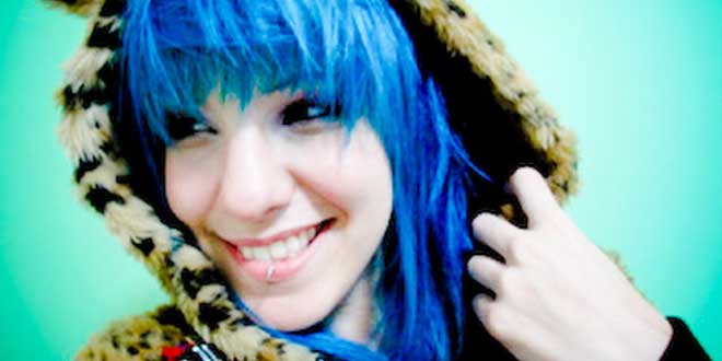 Mujer con el pelo azul, sonriendo, segura de sí misma