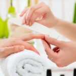 woman-in-nail-salon-receiving-manicure-picture-id465161243