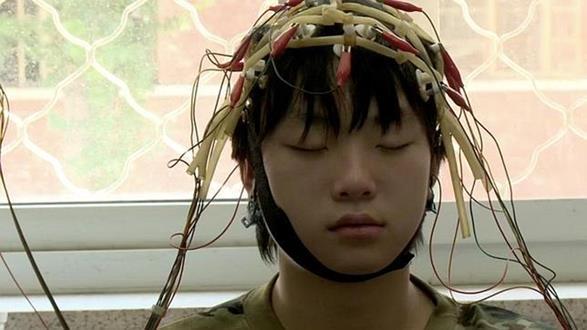 niño chino con cables en la cabeza