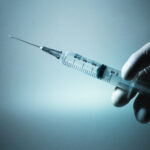 Doctor holding medical injection syringe